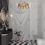 A bathroom with black and white marble walls, a gold chandelier, and a porcelain slab.